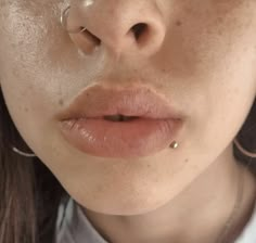 a woman with piercings on her nose looking at the camera