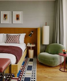 a bed sitting in a bedroom next to a chair and table on top of a hard wood floor