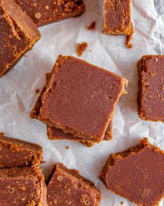 pieces of brownie sitting on top of a piece of parchment paper next to each other