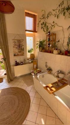 a bathroom with a tub, sink and toilet in it's center area next to a window