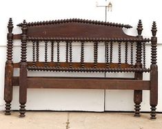 an old wooden bench sitting in front of a white wall