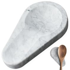 a white marble sink with a wooden spoon next to it on a white background,