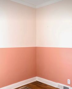 an empty room with pink and white walls