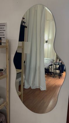 a mirror that is on the side of a wall next to a ladder and bed