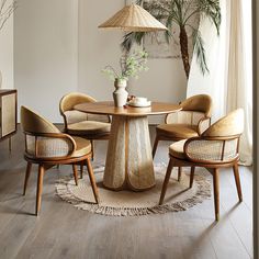 a round table with chairs and a lamp in the corner next to a plant on a rug