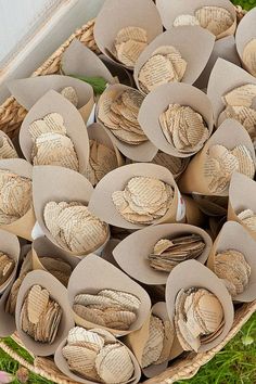 a basket filled with lots of different types of paper flowers on top of green grass