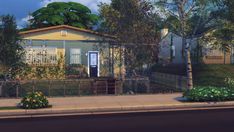 a small yellow house sitting on the side of a road next to a fence and trees