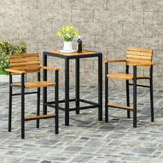 three wooden chairs and a table with flowers on it