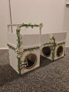 two white dog houses decorated with flowers and vines