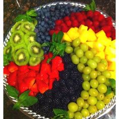 a platter filled with different types of fruits and veggies on top of a table