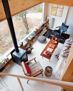 a living room filled with furniture and a fire place in the middle of a floor to ceiling window