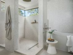 a bathroom with white walls and flooring next to a bathtub