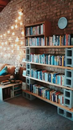 a living room filled with lots of books on shelves next to a couch and coffee table