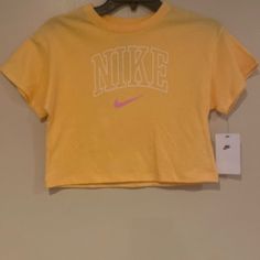 Brand New Girls Yellow, White And Pink Crop Tee Shirt Sporty Yellow T-shirt With Letter Print, Yellow Letter Print Tops, Nike Cotton Tops For Spring, Yellow Graphic Tee With Letter Print, Yellow Letter Print Graphic Tee, Nike Short Sleeve Tops For Spring, Trendy Nike T-shirt For Spring, Nike Basic Tops For Spring, Trendy Nike Top With Letter Print