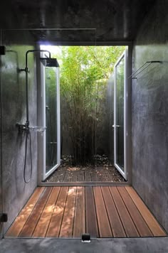 an outdoor shower with wooden flooring and walls