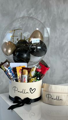 a gift basket filled with chocolates, candy and candies sits on a table