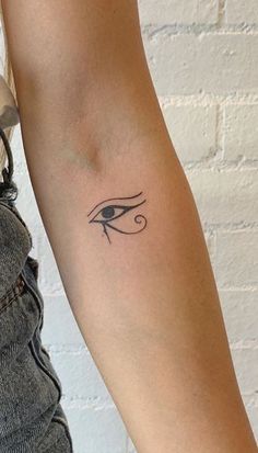 a woman's arm with an eye tattoo on the left side of her arm