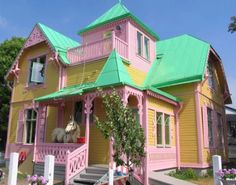 a pink and yellow house with a green roof