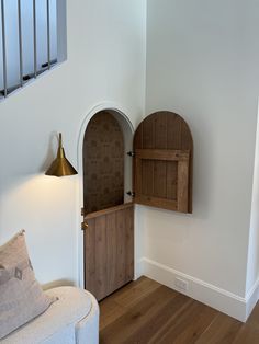 a living room with a white couch and wooden cabinet next to a wall mounted light