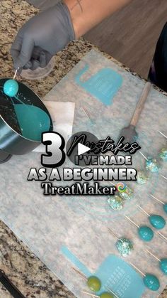 a person in gloves is making something on a table with teal colored buttons and spoons