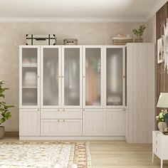 a living room filled with furniture next to a white wall mounted cabinet and potted plant