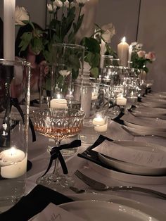 a long table is set with candles and place settings for dinner guests to sit at