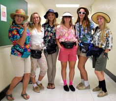 four girls are standing in a hallway with hats on their heads and one girl is holding a camera