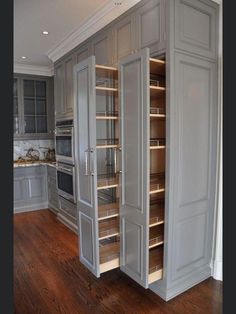 a kitchen with gray cabinets and wooden floors