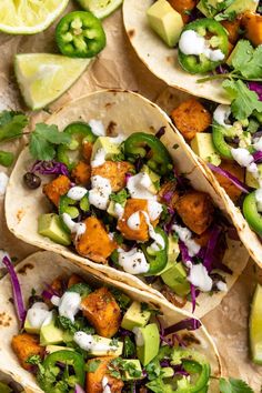 three fish tacos with avocado, cilantro and sour cream