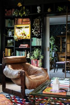 a living room filled with lots of furniture and bookshelves full of plants on shelves