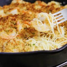 a close up of a fork in a casserole dish with shrimp and noodles