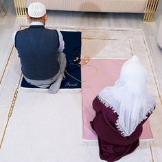 a man sitting on the floor next to a woman who is wearing a white veil