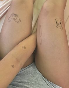 two people with tattoos on their legs laying in bed next to each other, one has a knife and the other has a dog