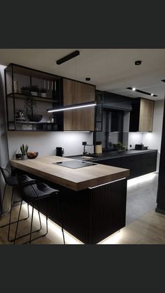 an image of a modern kitchen setting with lights on the counter top and black chairs