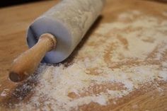 a rolling pin sitting on top of a wooden table covered in powdered sugar and flour