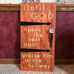 a wooden sign that says until god opens the next door praise him in the hallway