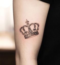 a small crown tattoo on the arm