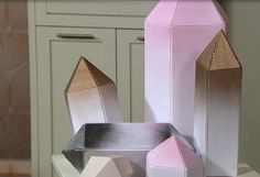 some pink and silver objects sitting on a table in front of cupboards with drawers