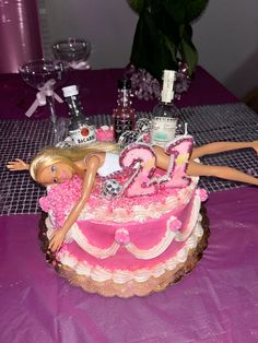 a birthday cake decorated with barbie dolls and decorations