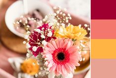 a vase filled with flowers sitting on top of a table next to a bowl of food