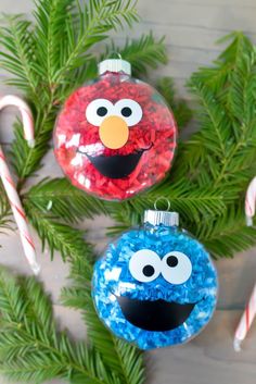 two christmas ornaments made to look like the characters from sesame and cookie monster, one with candy canes