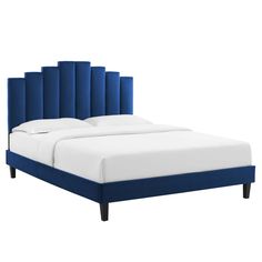 an upholstered bed with blue headboard and white sheets on the bottom side