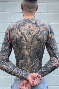 the back of a man with tattoos on his body and hands in front of him