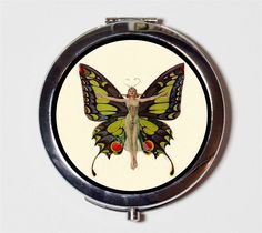 a small mirror with a painting of a butterfly on it's face and wings