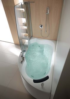 a bathroom with a tub and shower head mounted to the side of the bathtub