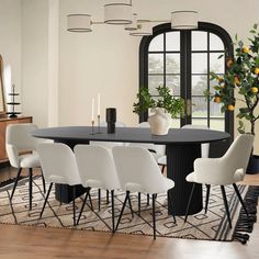 a dining room table with white chairs and a black round table in front of a large window