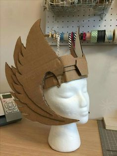 a paper headdress made to look like a helmet with feathers on the top