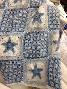 a blue and white crocheted blanket with stars on it