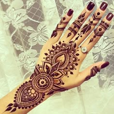 a henna tattoo on the palm of someone's hand, with an intricate design