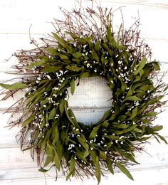 a wreath with white flowers and green leaves